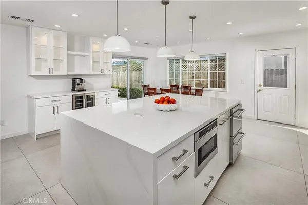 a kitchen that has a lot of cabinets in it and wooden floors