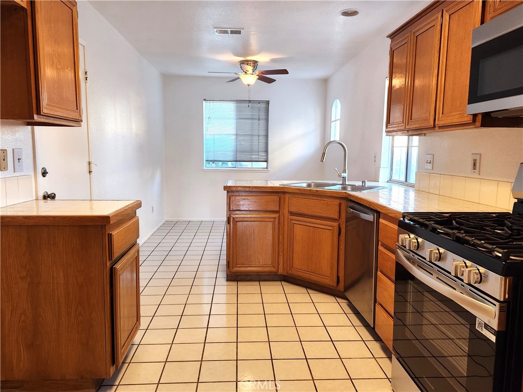 7545 Calais Court Rancho Cucamonga, CA 91730 - Photo 8 of 22 a kitchen with stainless steel appliances a sink stove top oven and cabinets