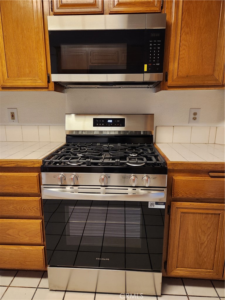 7545 Calais Court Rancho Cucamonga, CA 91730 - Photo 9 of 22 a kitchen with granite countertop cabinets and steel stove top oven