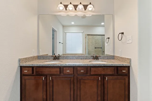 a spacious bathroom with a granite countertop sink mirror and shower
