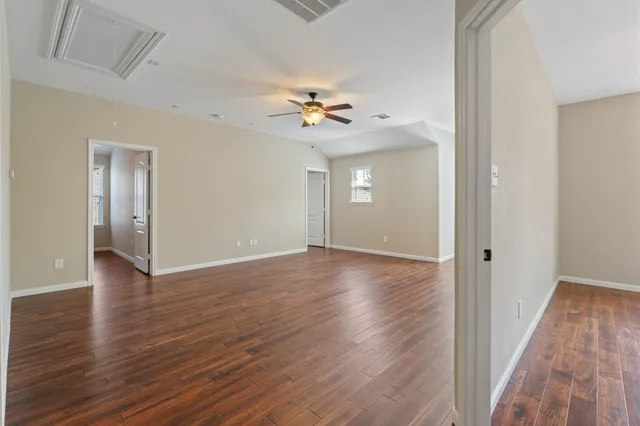 a view of an empty room with wooden floor