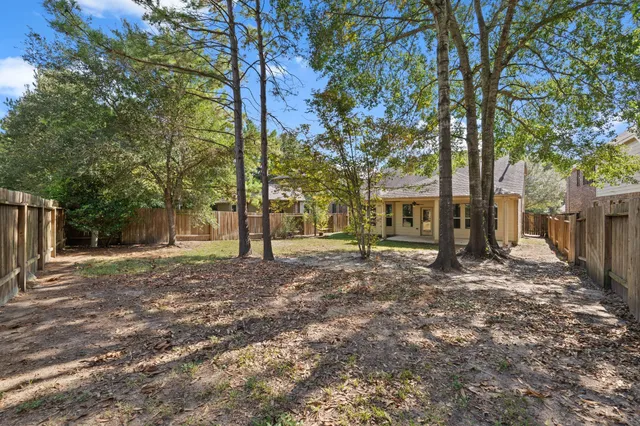 a patio with a yard a table and chairs