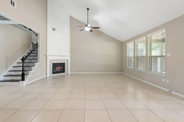 an empty room with windows and fireplace
