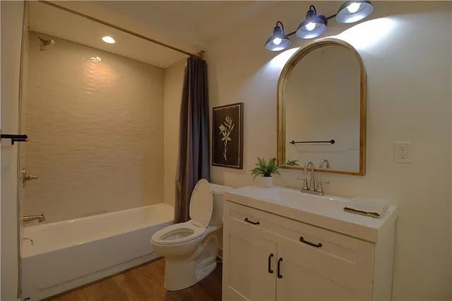 a view of hallway with stainless steel appliances wooden floor and fence
