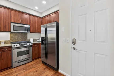 a kitchen with stainless steel appliances granite countertop a refrigerator microwave and sink