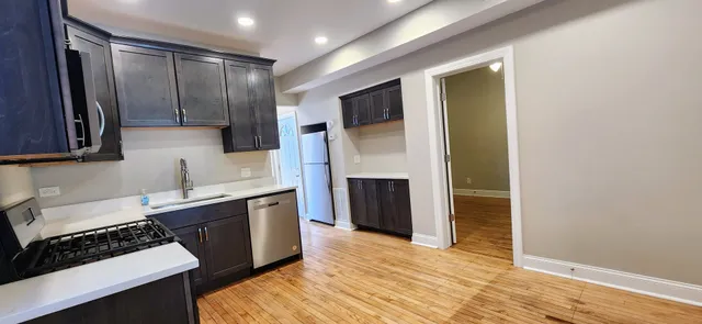 a kitchen with stainless steel appliances granite countertop a stove a sink and a refrigerator