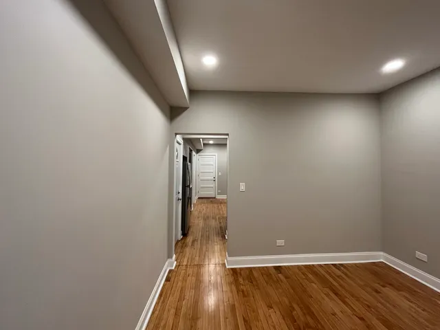 an empty room with wooden floor closet and fan