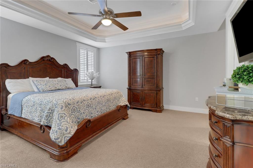 2825 Jenkins Way Naples, FL 34117 - Photo 17 of 50 a spacious bedroom with a bed and a chandelier