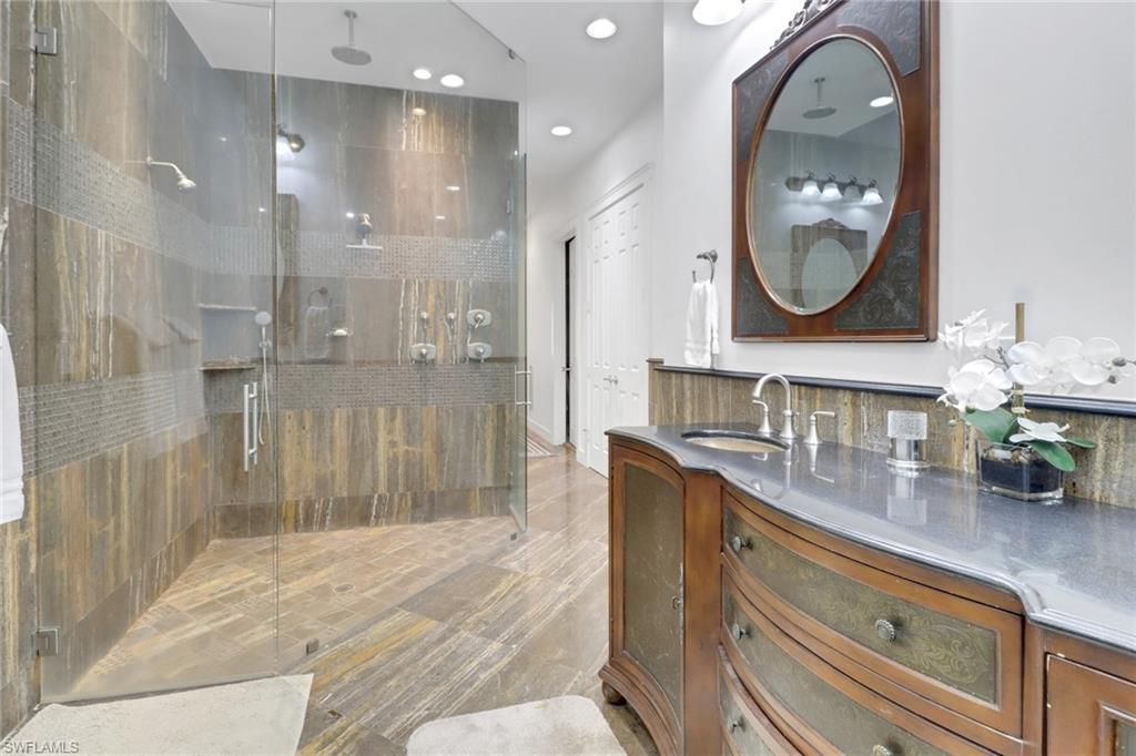 2825 Jenkins Way Naples, FL 34117 - Photo 30 of 50 a bathroom with a sink a mirror and a shower