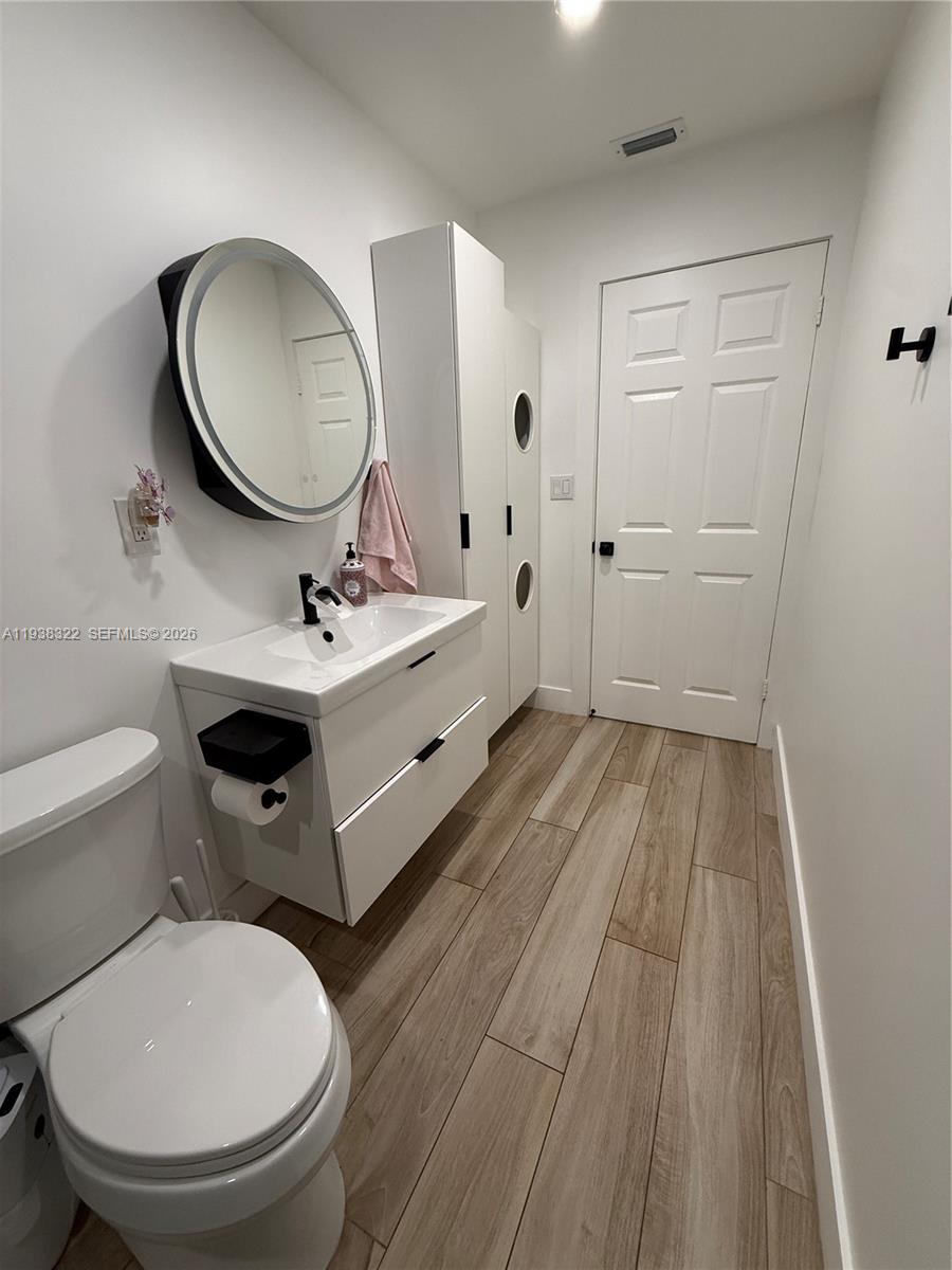 8335 Northwest 197th Terrace Hialeah, FL 33015 - Photo 35 of 51 a bathroom with a toilet a sink and mirror