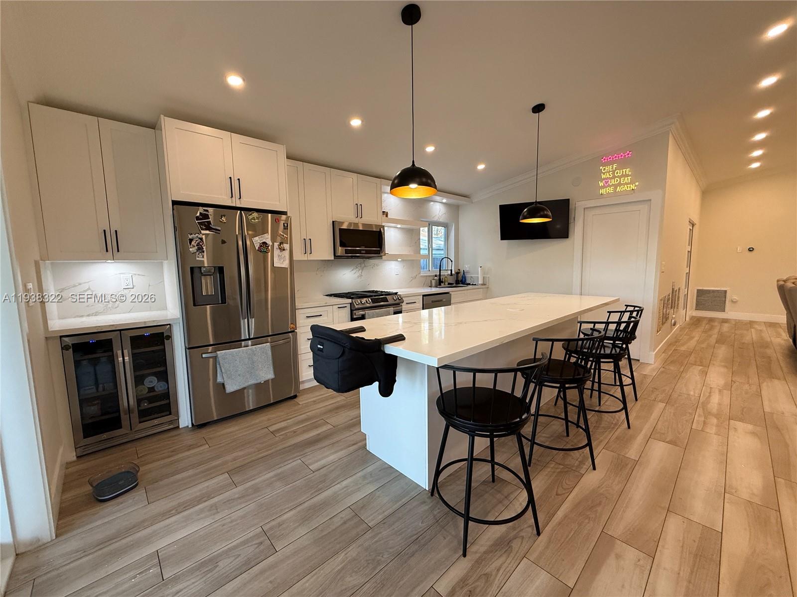 8335 Northwest 197th Terrace Hialeah, FL 33015 - Photo 8 of 51 a kitchen with stainless steel appliances a dining table chairs microwave and refrigerator