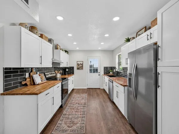 a picture of a room with a white wall and a refrigerator