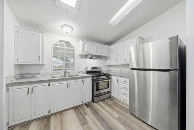 a spacious bedroom with a bed and a potted plant