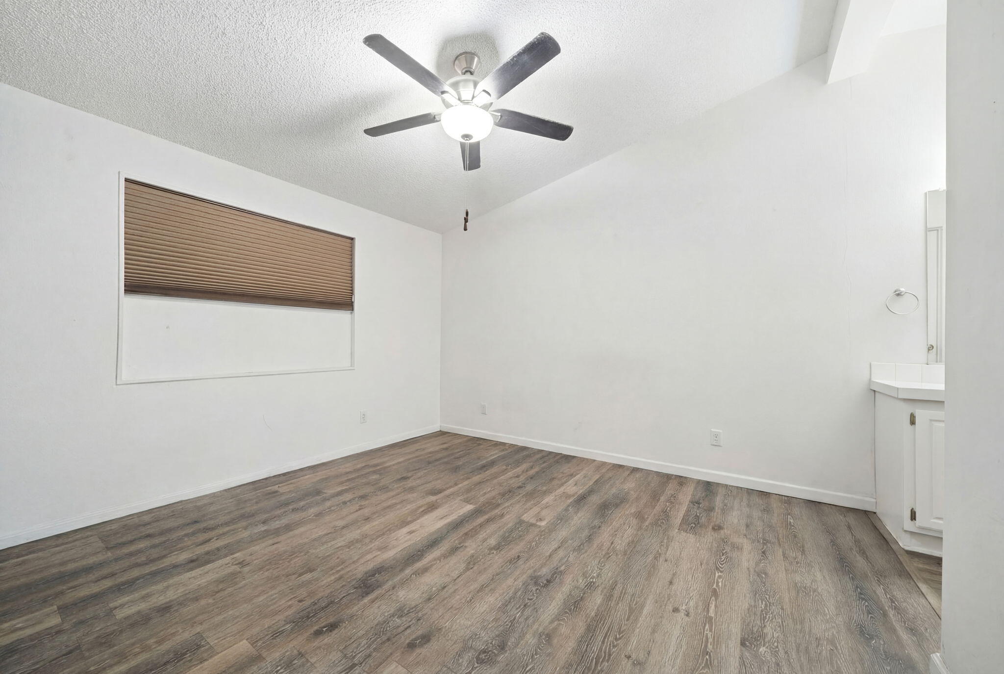 11705 Parey Avenue, Unit 7 Red Bluff, CA 96080 - Photo 19 of 34 an empty room with wooden floor and windows
