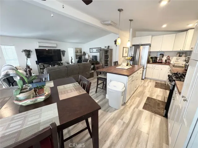 a view of a dining room with furniture a rug and wooden floor