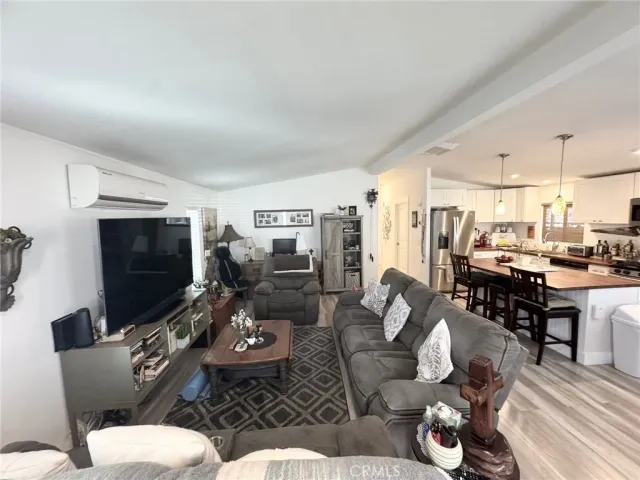 a living room with furniture kitchen view and a flat screen tv