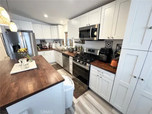 a kitchen with sink a microwave a refrigerator and cabinets