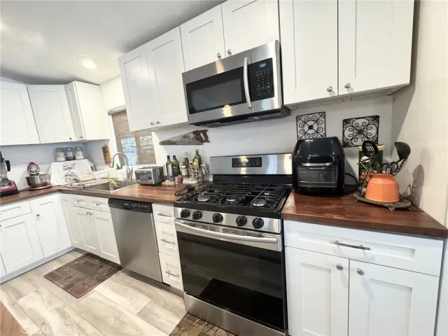 a kitchen with stainless steel appliances granite countertop a sink a stove a microwave and cabinets