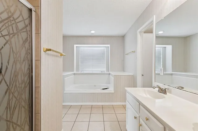 a spacious bathroom with a double vanity sink a mirror and a