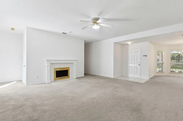 an empty room with a ceiling fan and a window