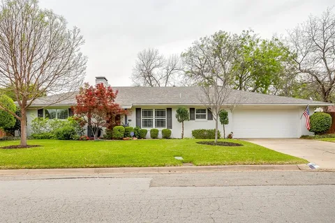 a front view of a house with a yard and potted plants