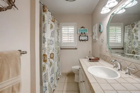 a bathroom with a sink a toilet and a mirror