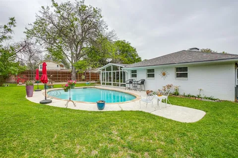 a view of a house with a backyard and a small pool