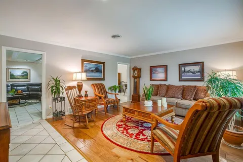 a living room with furniture a wooden floor and a large window