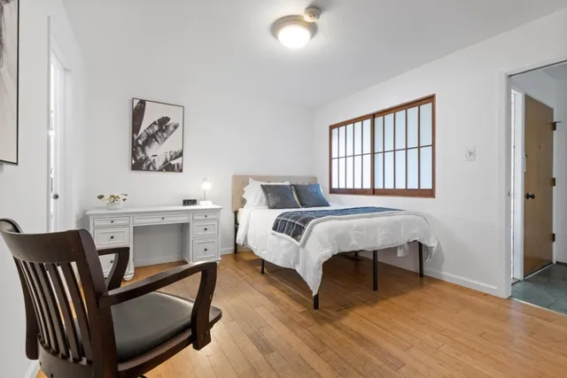 a bedroom with a bed and a table chair