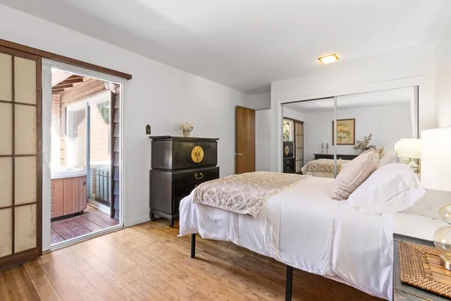 a bedroom with a bed and wooden floor