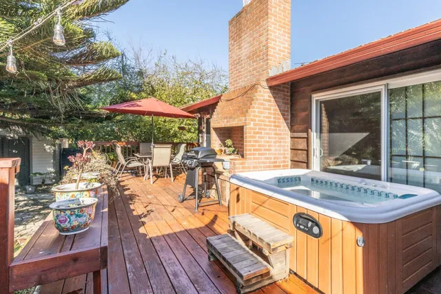a view of a patio with table and chairs under an umbrella with wooden floor