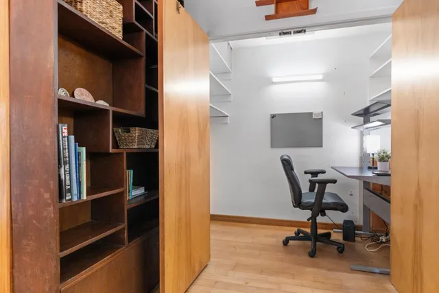 a view of a workspace with furniture and a window