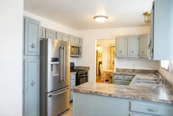 a kitchen with granite countertop a refrigerator and a sink