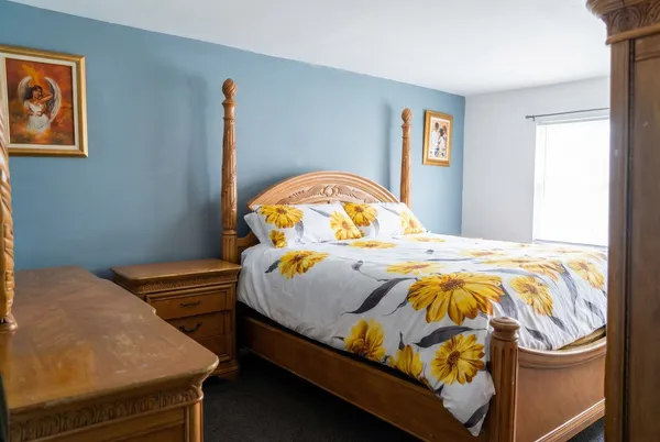 a bed sitting in a bedroom next to a window