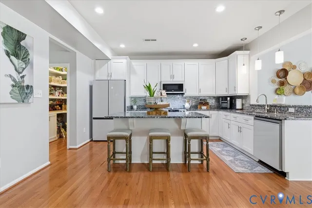 a kitchen with white cabinets and appliances