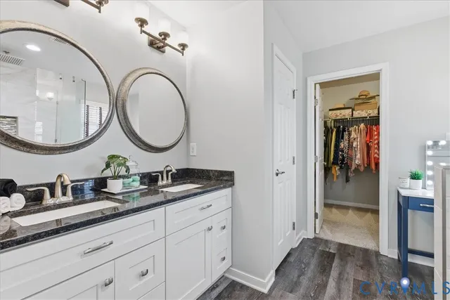 a bathroom with a double vanity sink mirror and toilet
