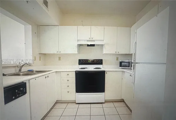 a kitchen with a stove sink and cabinets