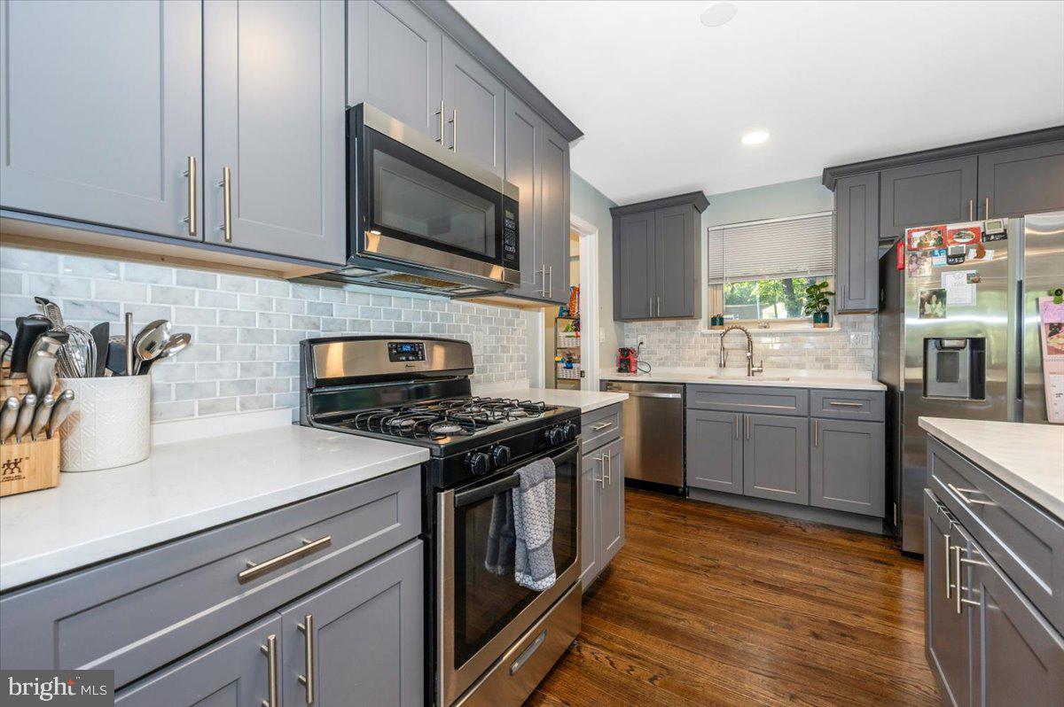 2208 Muskogee Street Adelphi, MD 20783 - Photo 25 of 71 a kitchen with stainless steel appliances a sink dishwasher stove and microwave with wooden floor