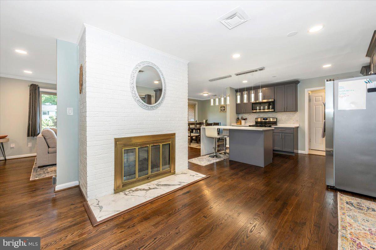 2208 Muskogee Street Adelphi, MD 20783 - Photo 28 of 71 a living room with stainless steel appliances kitchen island a fireplace furniture a stove and a refrigerator