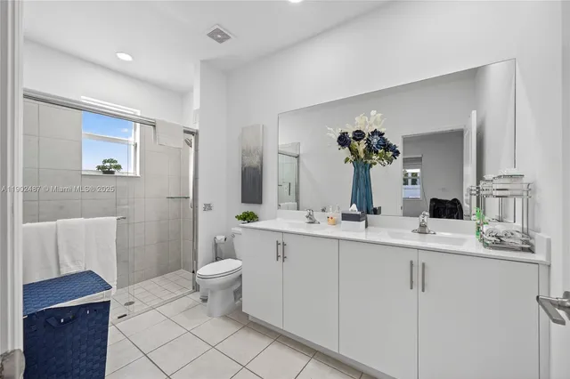 a bathroom with a double vanity sink toilet and a mirror