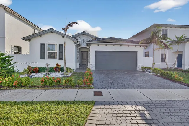 a front view of a house with a yard and potted plants