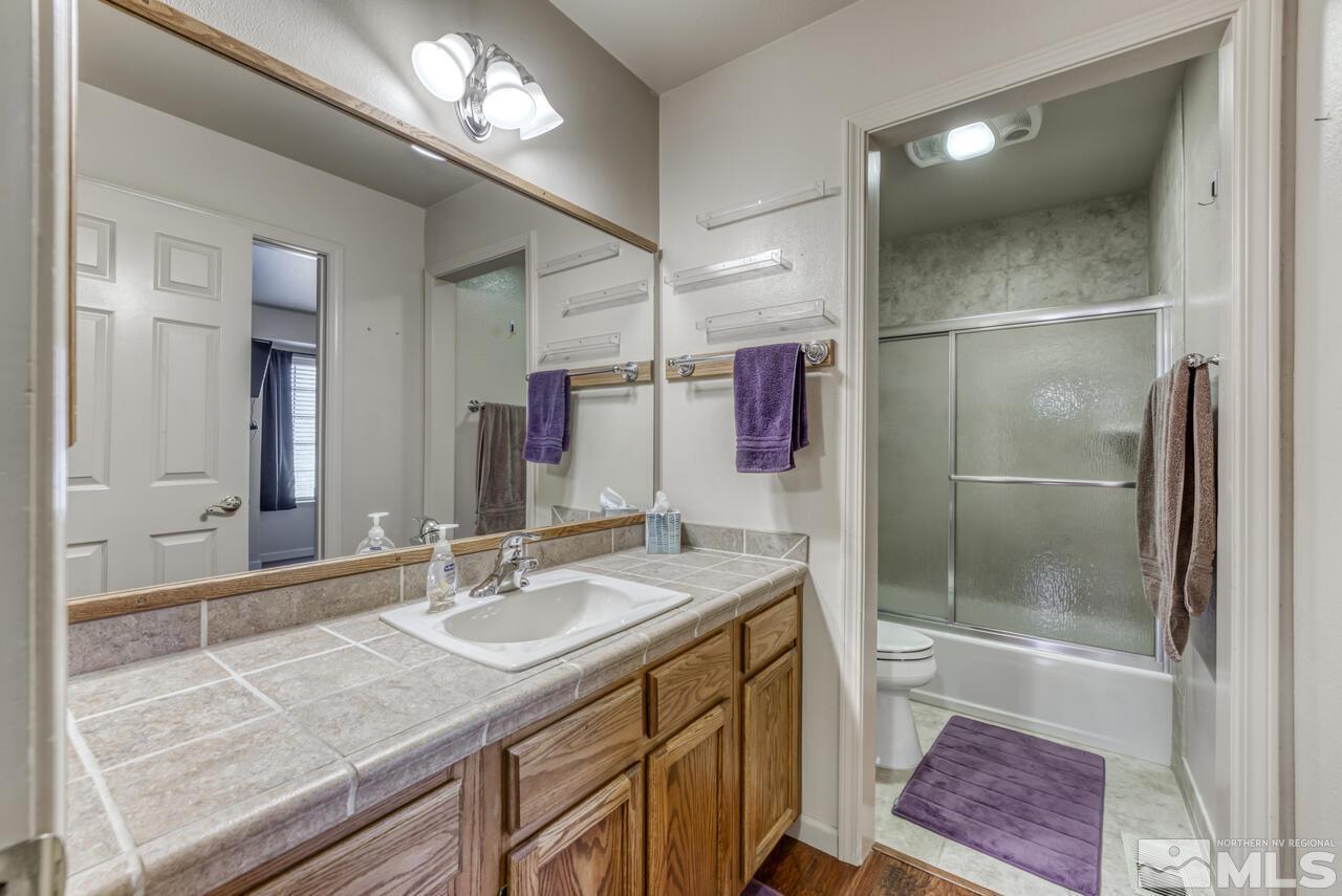 5325 Mountcrest Lane Reno, NV 89523 - Photo 12 of 17 a bathroom with a granite countertop sink a mirror and a shower