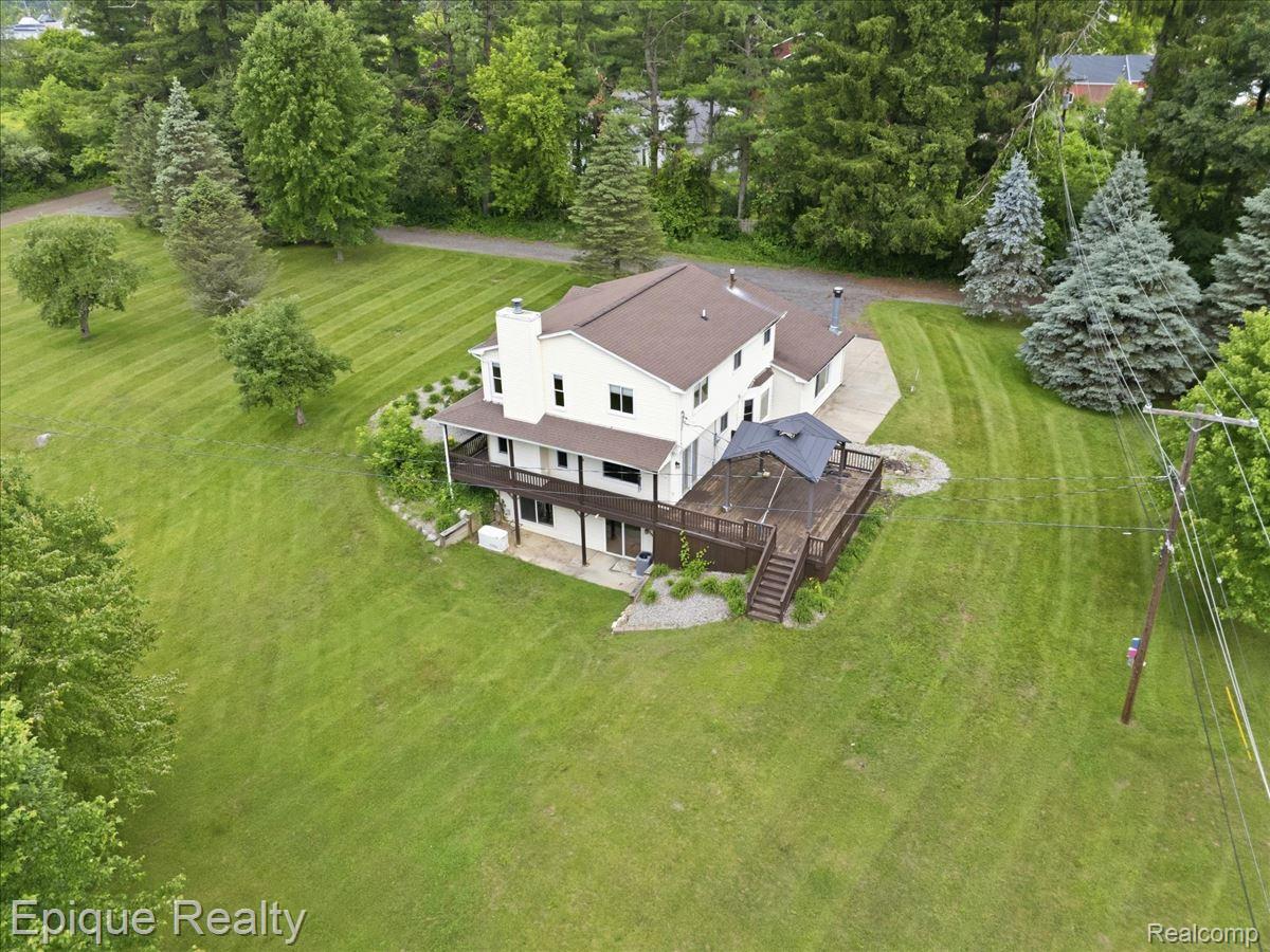 1221 Rhodes Road Lake Orion, MI 48360 - Photo 71 of 72 Expansive green lawn surrounds a multi-level residence featuring a broad wood deck with a gazebo