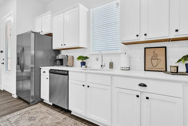 a kitchen with stainless steel appliances white cabinets and a refrigerator