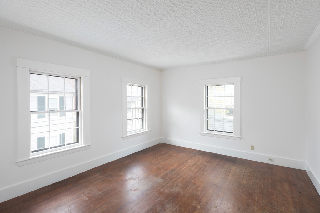 12 Farwell Place, Unit 12 Cambridge, MA 02138 - Photo 15 of 17 an empty room with wooden floor and windows