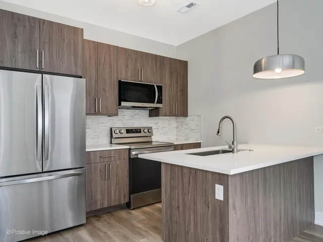 a kitchen with stainless steel appliances granite countertop a refrigerator a stove a sink dishwasher and a refrigerator with wooden floor