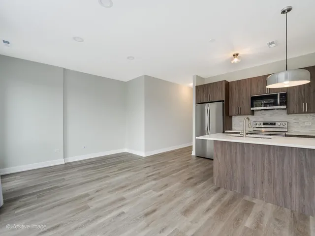 a view of kitchen with wooden floor and electronic appliances