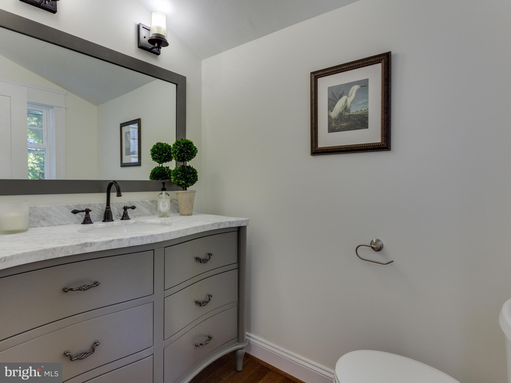 3722 Chesapeake Street Northwest Washington, DC 20016 - Photo 11 of 30 a bathroom with a granite countertop toilet sink and mirror