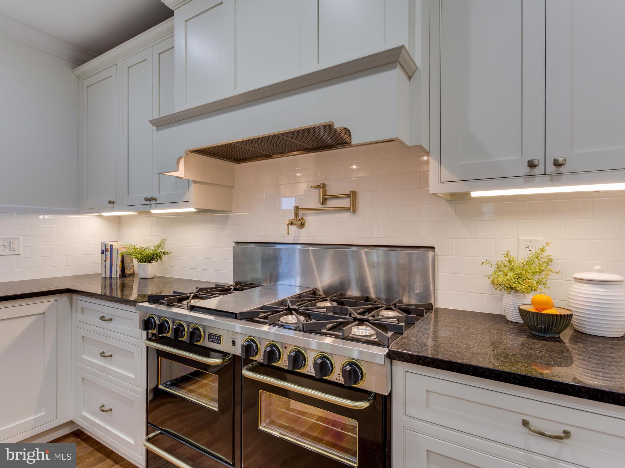 3722 Chesapeake Street Northwest Washington, DC 20016 - Photo 9 of 30 a kitchen with stainless steel appliances granite countertop white cabinets and a stove