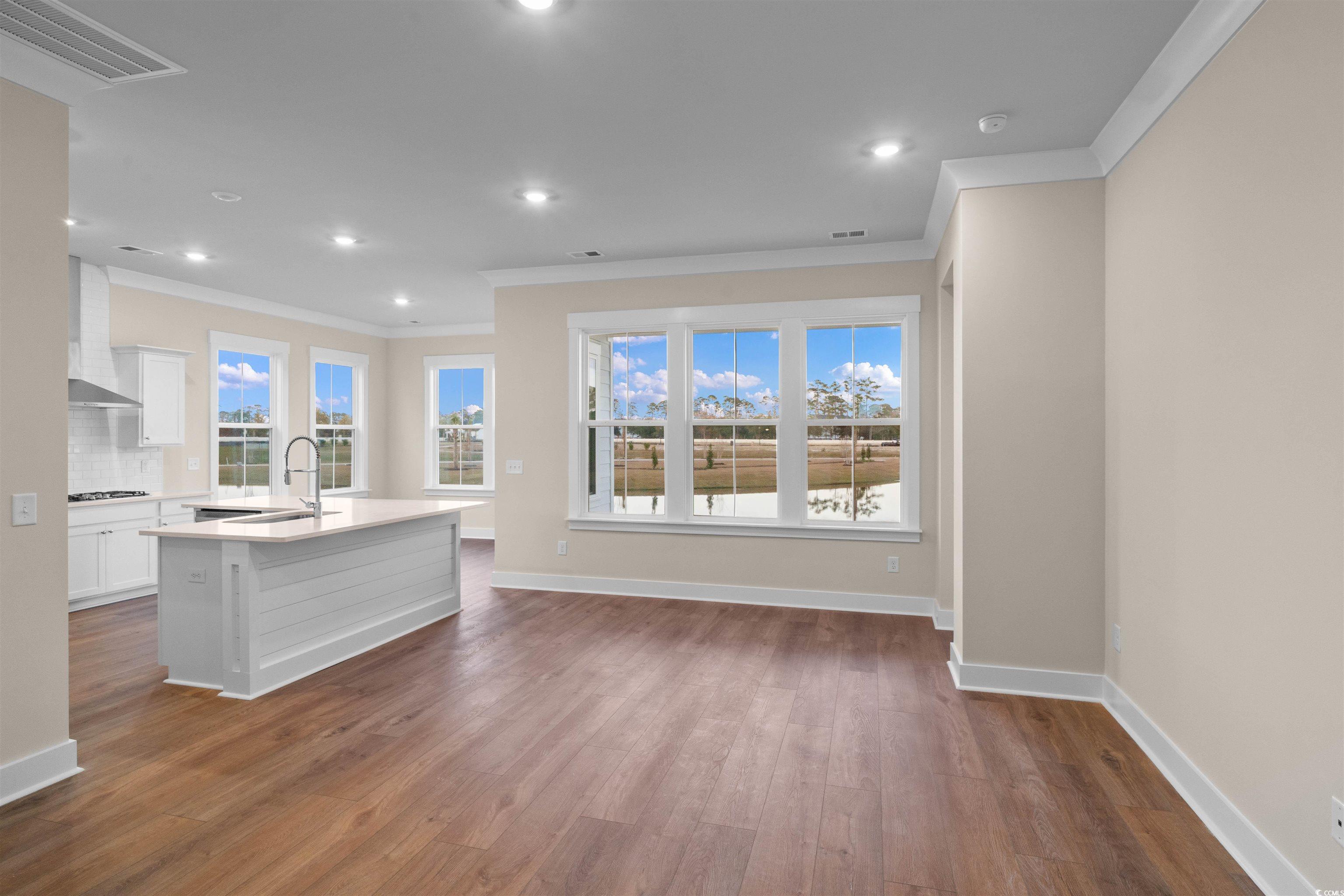 224 Atlantic Breeze Street Myrtle Beach, SC 29572 - Photo 20 of 39 Unfurnished living room featuring dark wood-style floors, ornamental molding, recessed lighting, and healthy amount of natural light